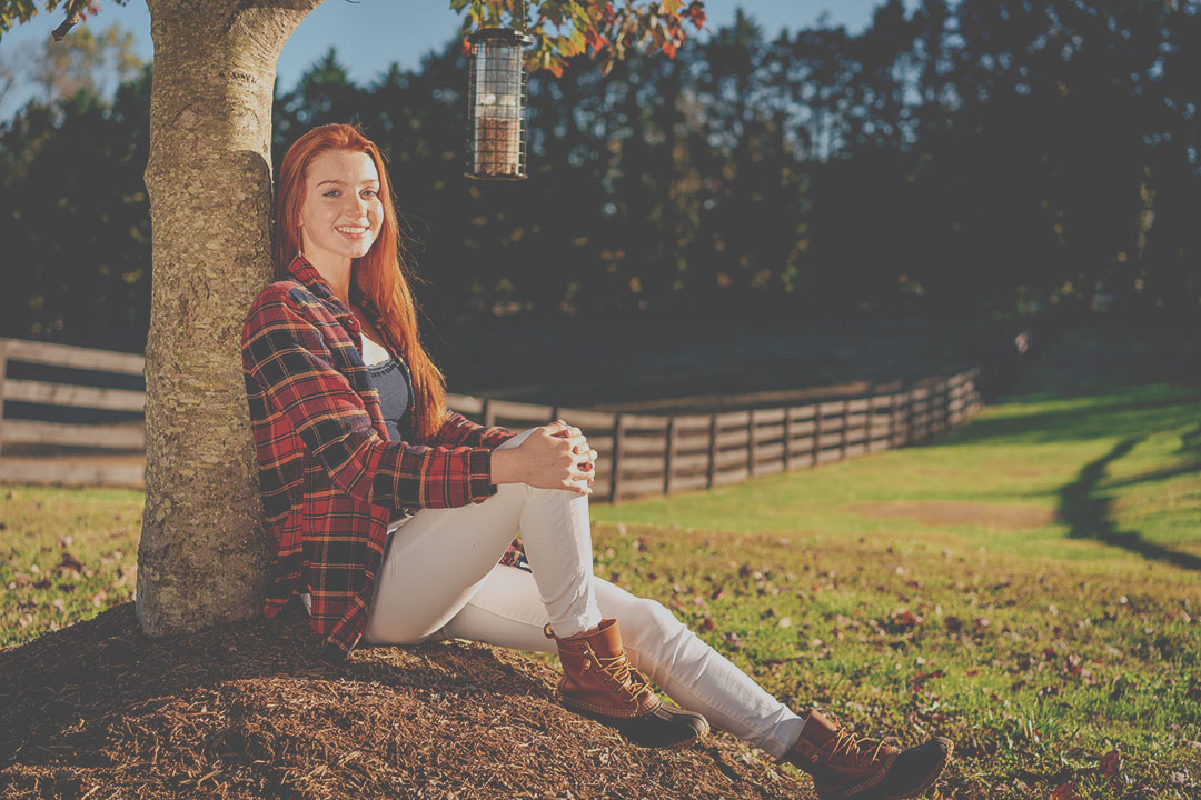 teen under tree smiling